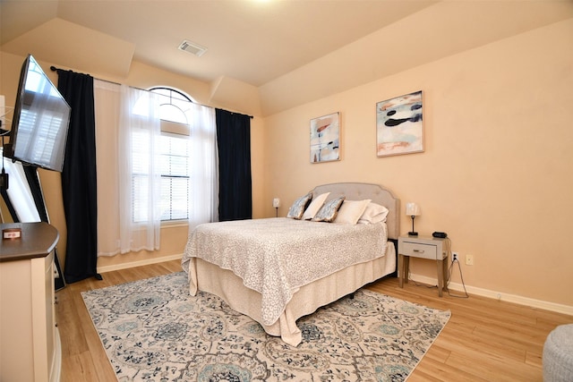 bedroom featuring vaulted ceiling and light wood-type flooring