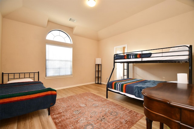 bedroom with hardwood / wood-style flooring and lofted ceiling