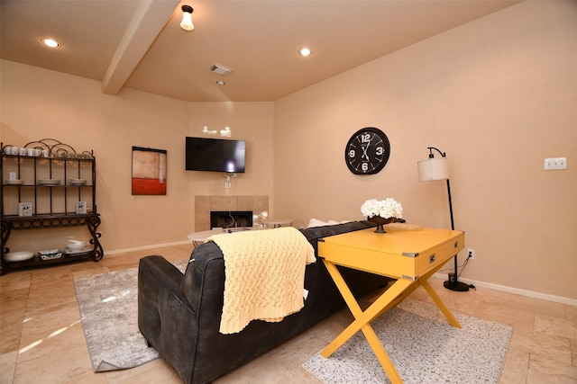 living room with beamed ceiling and a tiled fireplace