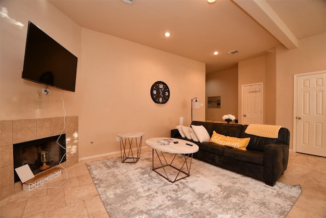 living room with beamed ceiling and a tiled fireplace