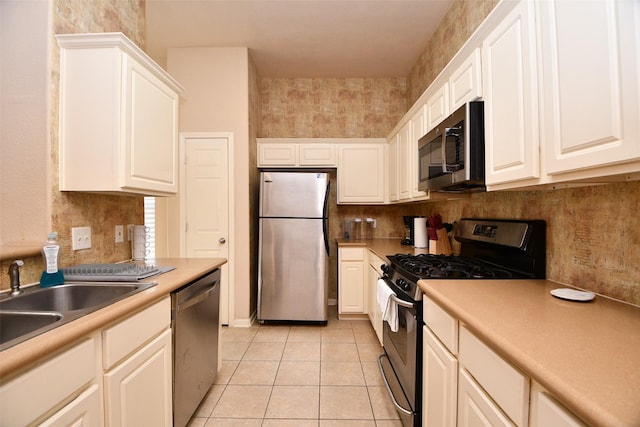 kitchen featuring white cabinets, light tile patterned flooring, sink, and stainless steel appliances