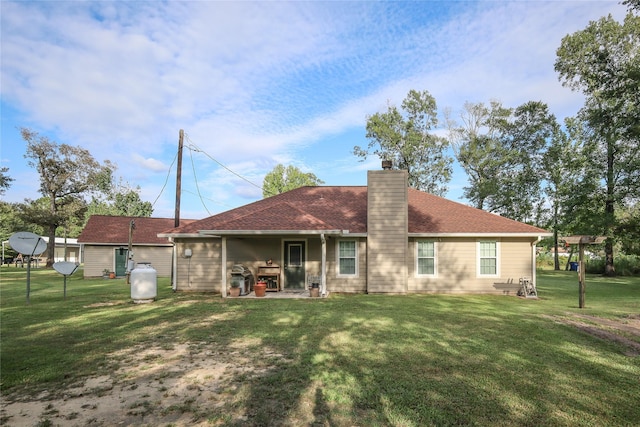 back of property with a patio area and a yard