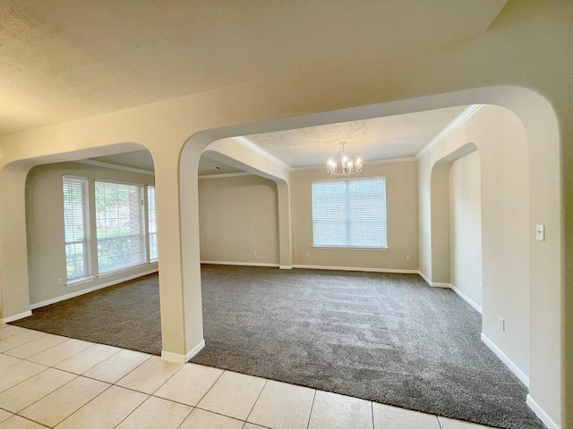 empty room with light carpet, crown molding, a healthy amount of sunlight, and an inviting chandelier