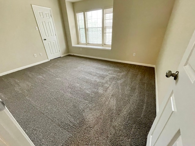 empty room featuring dark colored carpet