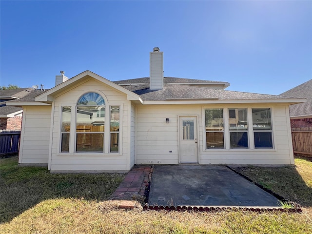 rear view of house featuring a lawn and a patio