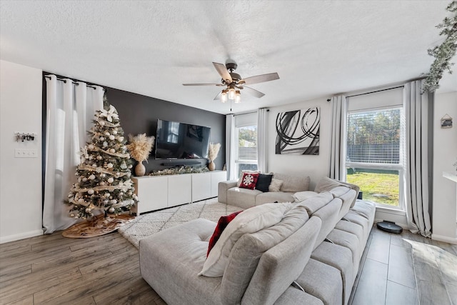 living room with ceiling fan, a healthy amount of sunlight, a textured ceiling, and wood-type flooring