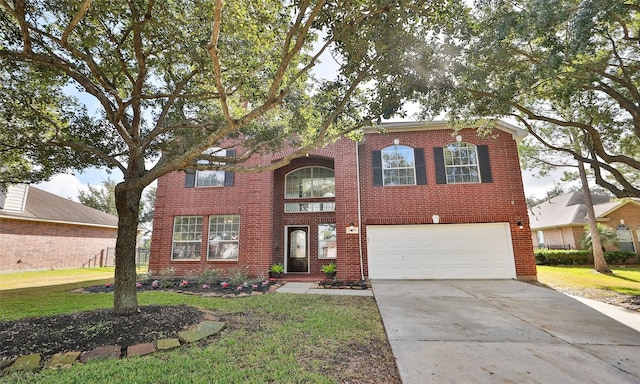 traditional-style house with an attached garage, driveway, brick siding, and a front yard