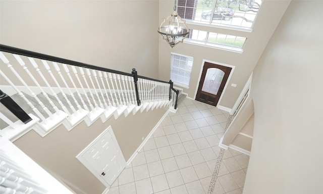 entrance foyer featuring light tile patterned flooring, a high ceiling, and a notable chandelier