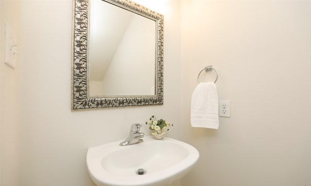 bathroom featuring sink and lofted ceiling