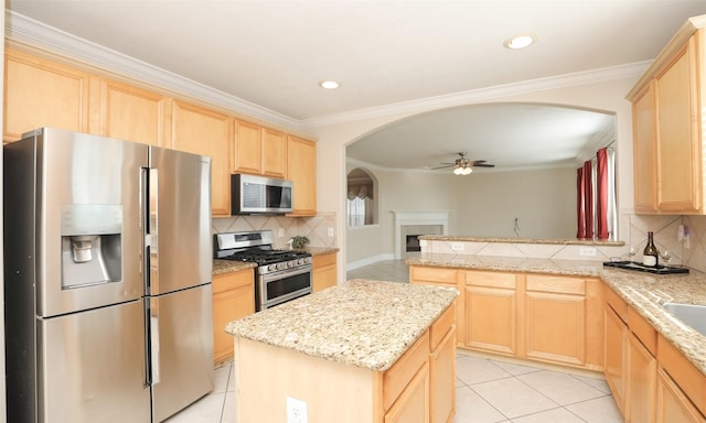 kitchen featuring backsplash, light brown cabinets, and appliances with stainless steel finishes