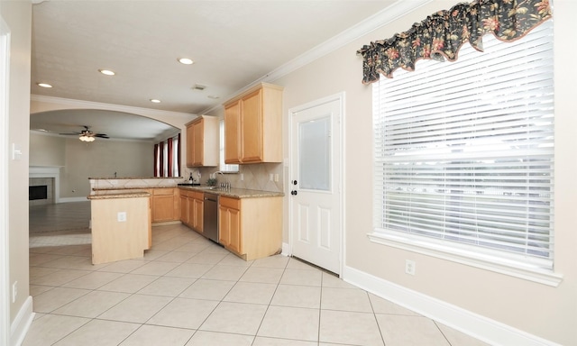 kitchen featuring kitchen peninsula, light brown cabinetry, stainless steel dishwasher, and ornamental molding