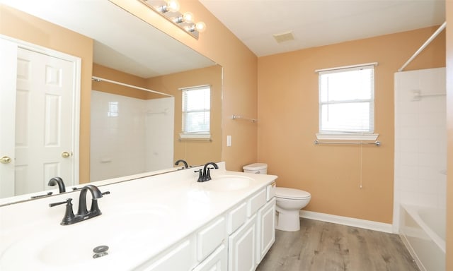 full bathroom with plenty of natural light, vanity, wood-type flooring, and toilet