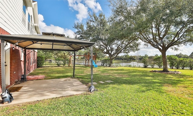 view of yard with a gazebo, a patio area, a water view, and a playground