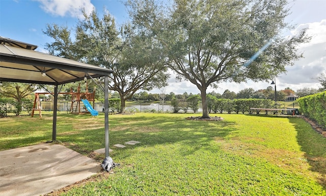 view of yard with a playground and a water view