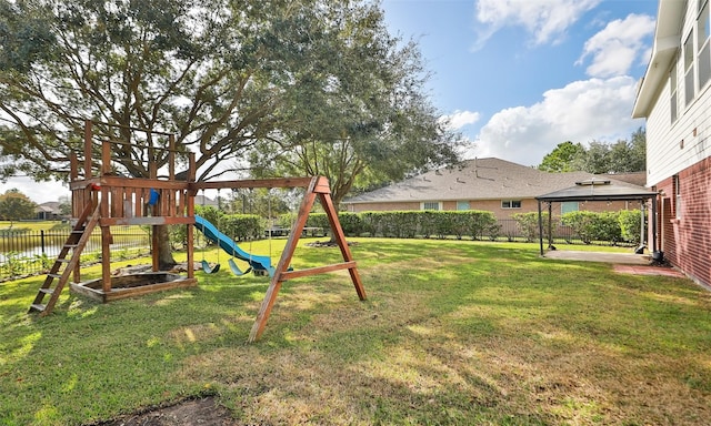 view of playground featuring a gazebo, a yard, and a water view