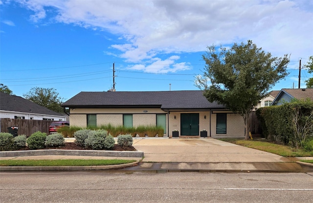 view of front of property with brick siding and fence