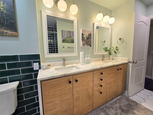 bathroom with double vanity, a sink, tile walls, and tile patterned floors