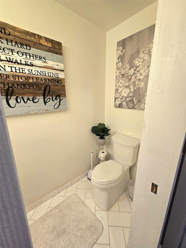 bathroom with baseboards, toilet, and tile patterned floors