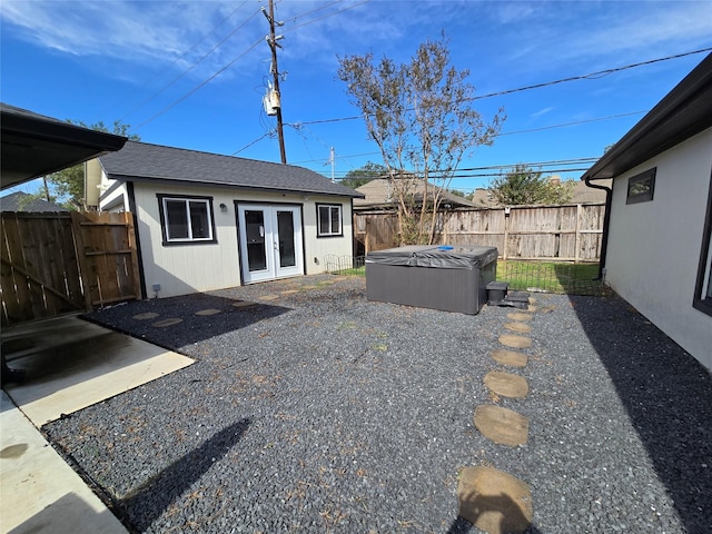 exterior space with a patio area, french doors, a fenced backyard, and a hot tub