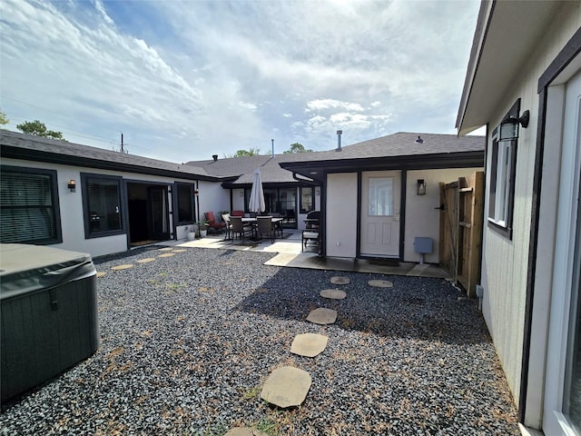 view of yard with a patio, outdoor dining space, and a hot tub