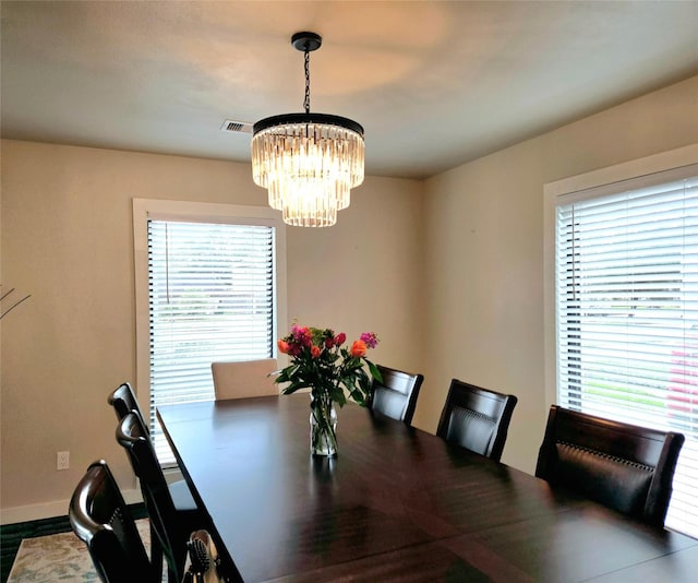 dining area with visible vents, baseboards, and an inviting chandelier