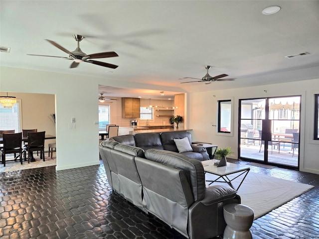 living area featuring a chandelier, visible vents, and baseboards