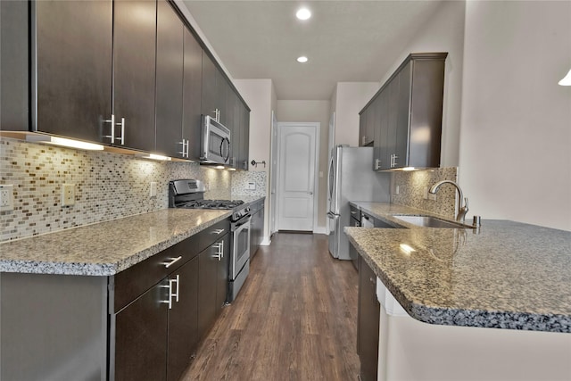 kitchen with decorative backsplash, dark hardwood / wood-style flooring, stainless steel appliances, and sink