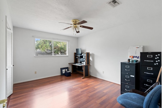 living area with a textured ceiling, ceiling fan, and dark hardwood / wood-style floors