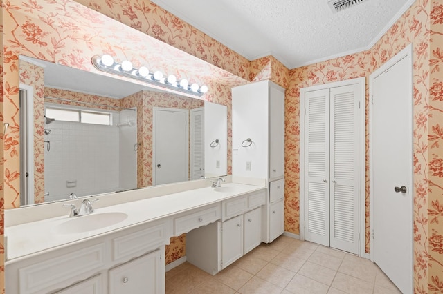 bathroom featuring tile patterned flooring, vanity, and a textured ceiling