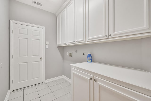 clothes washing area with hookup for an electric dryer, cabinets, light tile patterned floors, and hookup for a washing machine