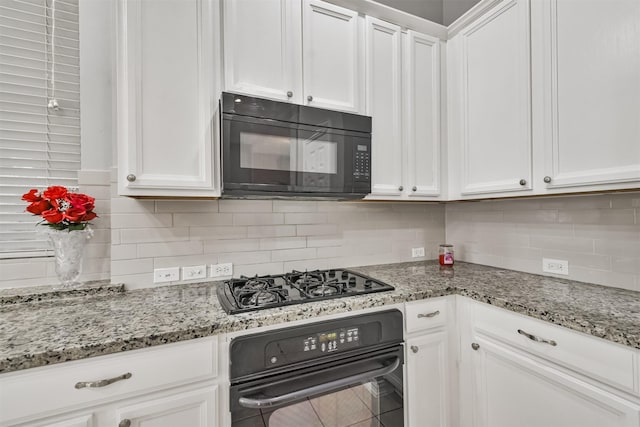 kitchen with black appliances, light stone counters, white cabinetry, and tasteful backsplash