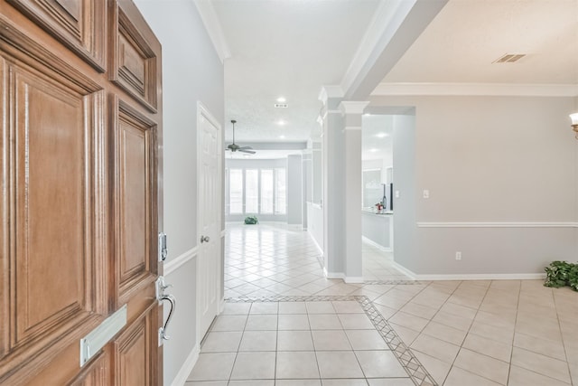 foyer with ornate columns, ceiling fan, crown molding, and light tile patterned floors