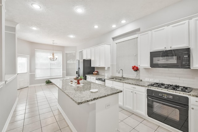 kitchen featuring white cabinets, sink, a kitchen island, and black appliances