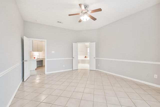 unfurnished bedroom with ensuite bathroom, ceiling fan, and light tile patterned flooring