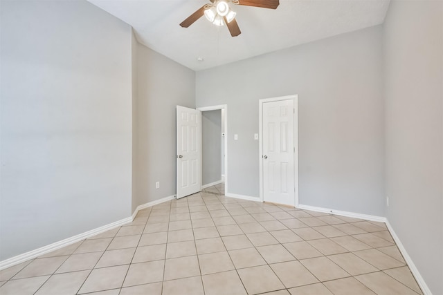 tiled spare room with ceiling fan