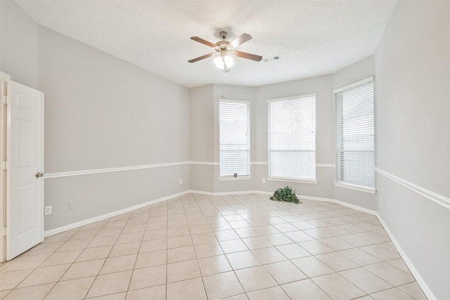 tiled empty room featuring ceiling fan