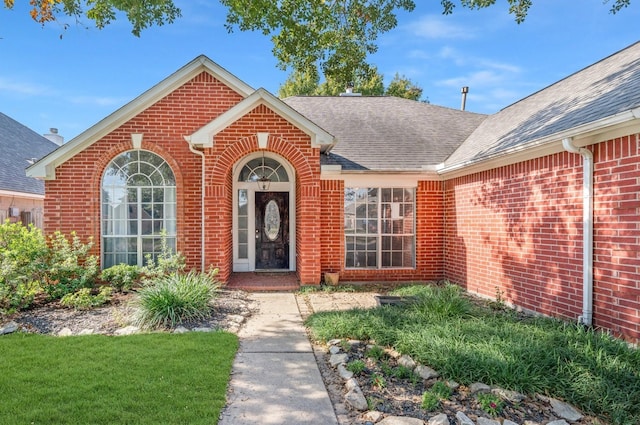 view of exterior entry with a yard