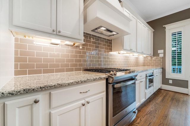 kitchen with stainless steel appliances, dark hardwood / wood-style floors, premium range hood, decorative backsplash, and ornamental molding