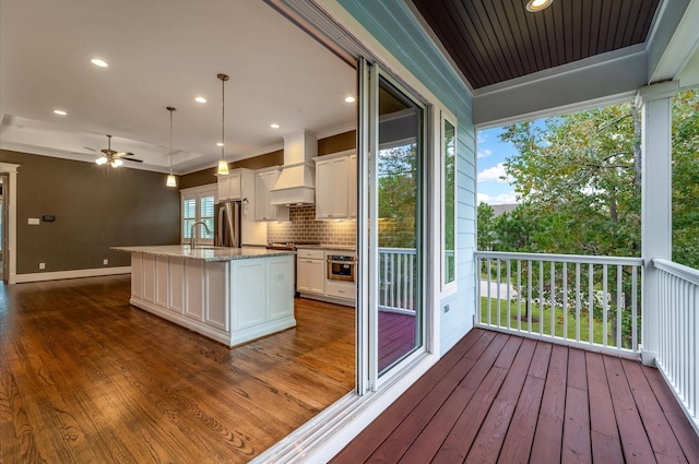 exterior space featuring dark hardwood / wood-style floors, white cabinetry, and premium range hood