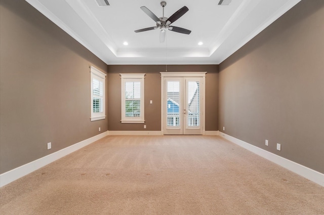 spare room featuring ceiling fan, french doors, crown molding, light colored carpet, and a tray ceiling