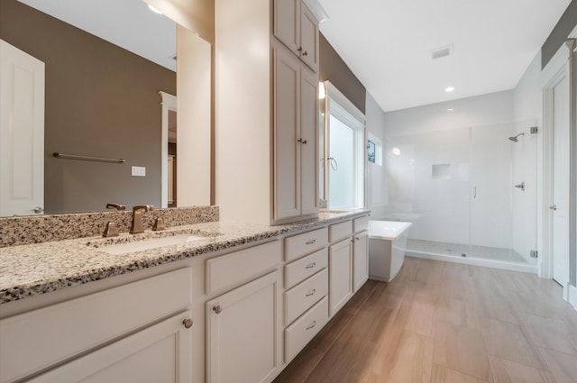 bathroom with vanity, hardwood / wood-style flooring, and separate shower and tub