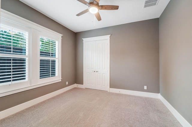 unfurnished bedroom featuring ceiling fan and light carpet