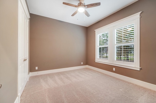 spare room with light carpet and ceiling fan