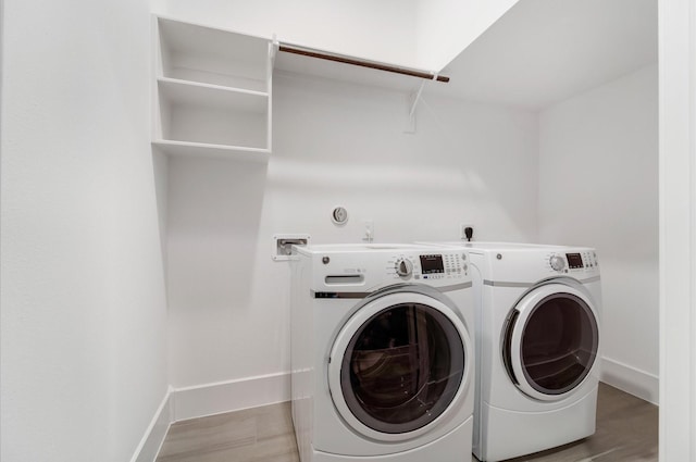 laundry area with light hardwood / wood-style flooring and independent washer and dryer