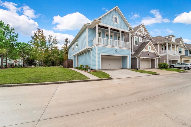 view of front of property featuring a balcony, a front yard, and a garage