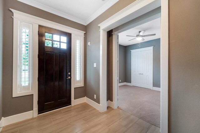 entryway featuring light hardwood / wood-style floors, ceiling fan, and crown molding