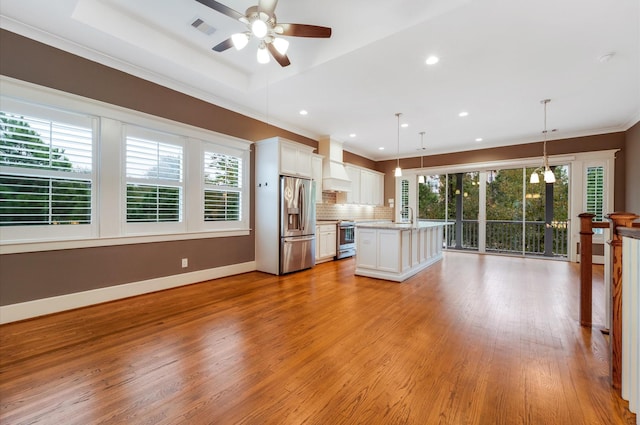 kitchen featuring white cabinets, plenty of natural light, hanging light fixtures, and stainless steel appliances