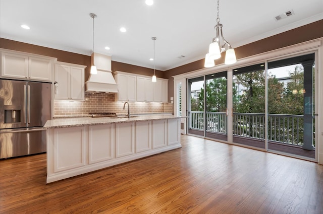 kitchen with white cabinets, a healthy amount of sunlight, light wood-type flooring, and stainless steel refrigerator with ice dispenser