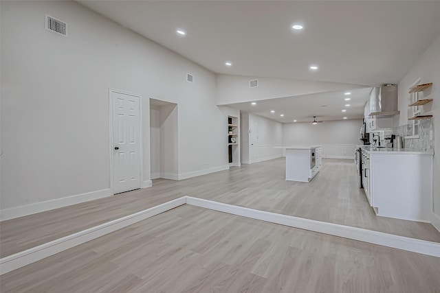 unfurnished living room with high vaulted ceiling, ceiling fan, and light hardwood / wood-style floors