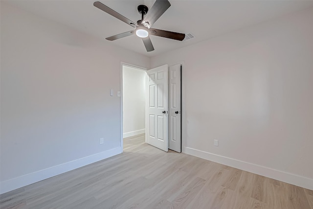 empty room with ceiling fan and light hardwood / wood-style flooring